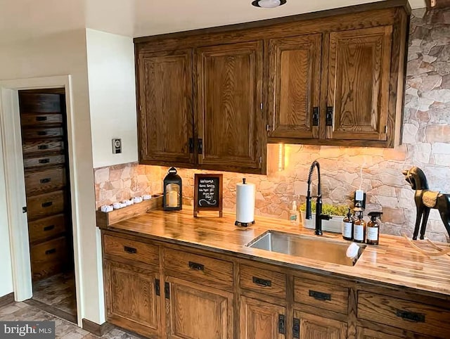 bar featuring decorative backsplash, butcher block counters, and sink