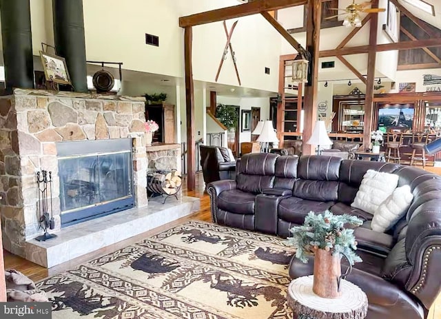 living room with a fireplace, hardwood / wood-style floors, high vaulted ceiling, and ceiling fan