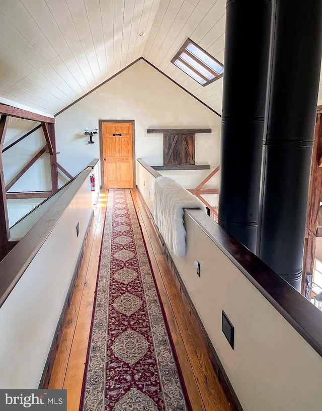 hallway with wood-type flooring, lofted ceiling with skylight, and wood ceiling