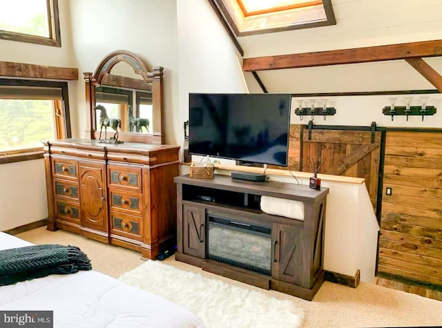 bedroom with a barn door and light colored carpet