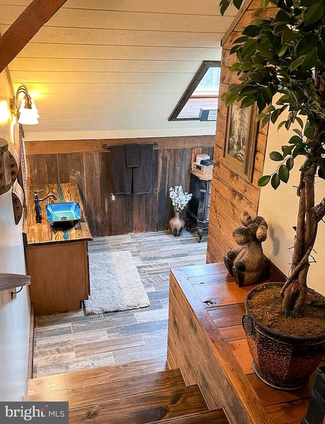 bathroom with a skylight, wood walls, and hardwood / wood-style flooring