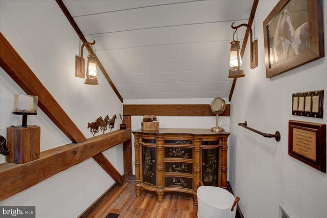 stairs featuring wood-type flooring and vaulted ceiling