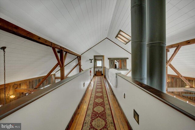 hall with wood-type flooring, vaulted ceiling, and wood ceiling