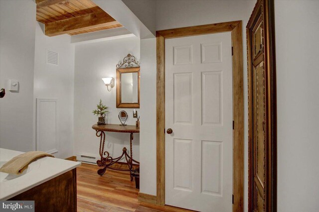 corridor featuring beam ceiling, light wood-type flooring, and wooden ceiling