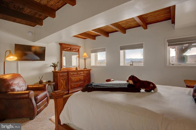 carpeted bedroom with beamed ceiling and wood ceiling