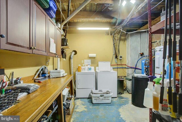 laundry room featuring a workshop area, cabinets, and washer and dryer