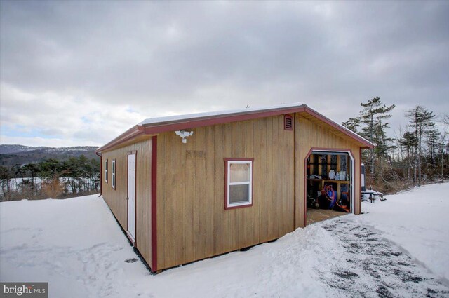 snow covered structure with a garage