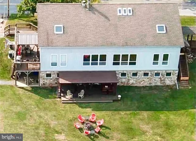 rear view of house featuring a lawn and a wooden deck