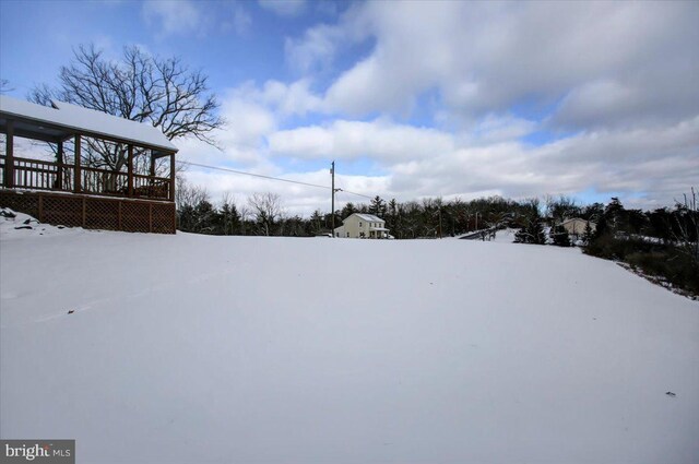 yard layered in snow with a wooden deck