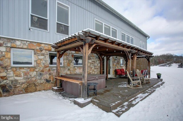 snow covered deck with a hot tub