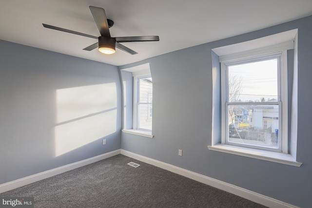 carpeted spare room featuring ceiling fan