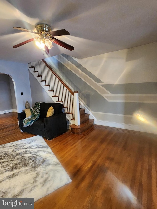 stairs featuring wood-type flooring and ceiling fan