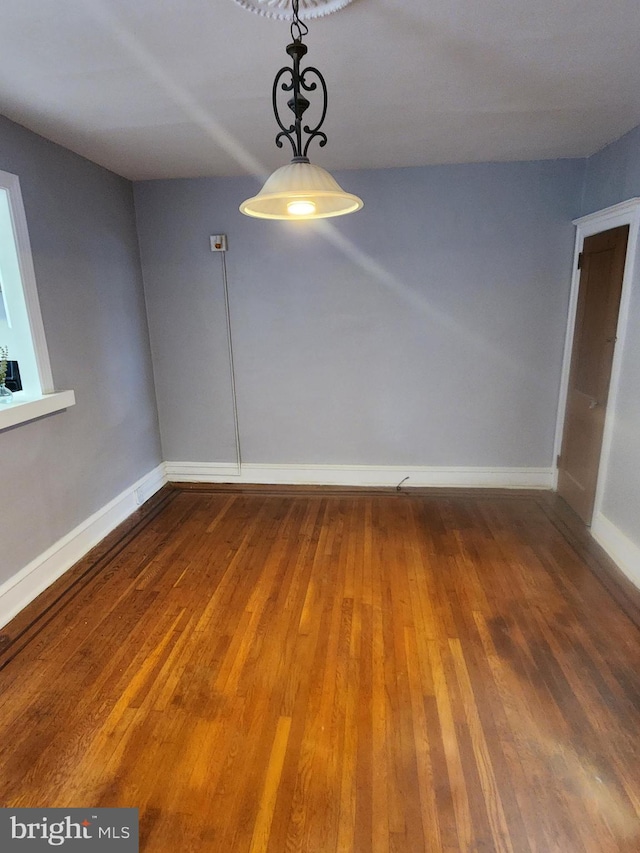 empty room with dark hardwood / wood-style flooring