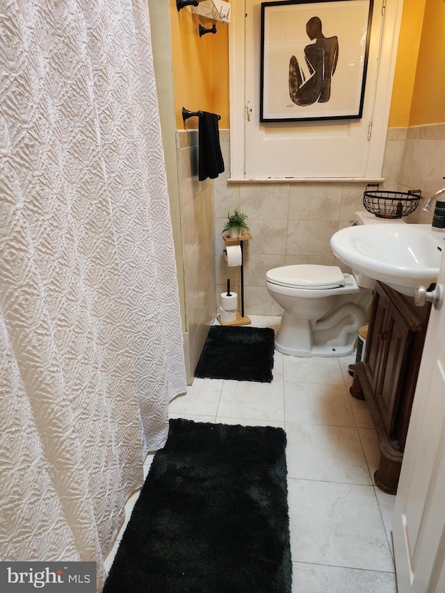 bathroom with tile patterned flooring, vanity, tile walls, and toilet