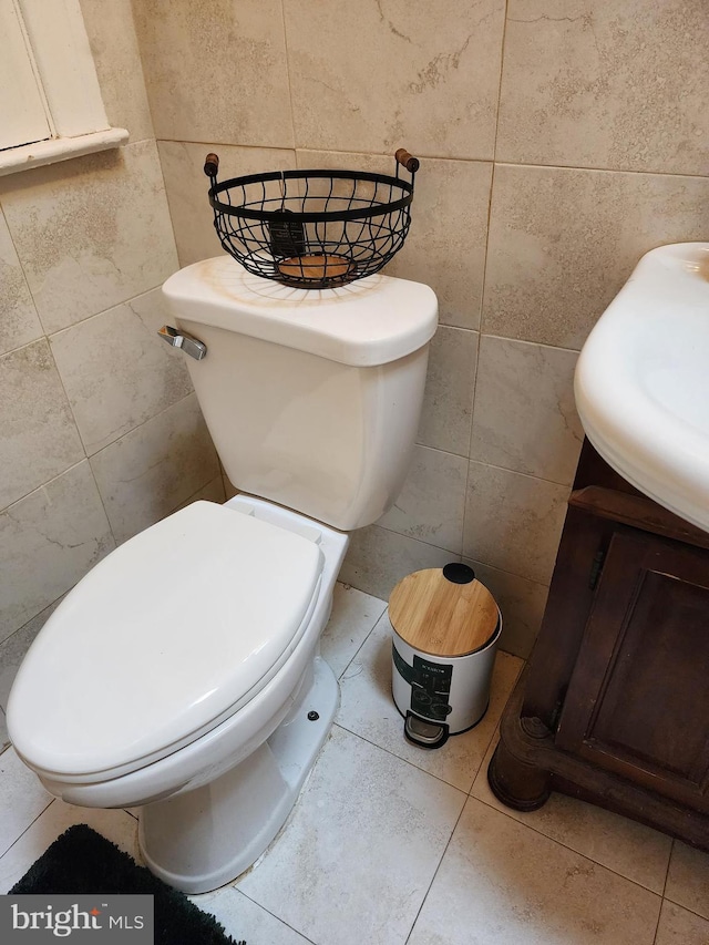 bathroom featuring toilet and tile walls