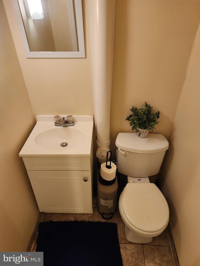 bathroom with tile patterned flooring, vanity, and toilet