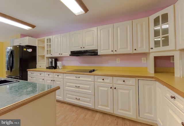 kitchen with white cabinetry, light wood-type flooring, and black appliances