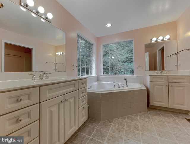 bathroom featuring vanity, a relaxing tiled tub, and tile patterned floors