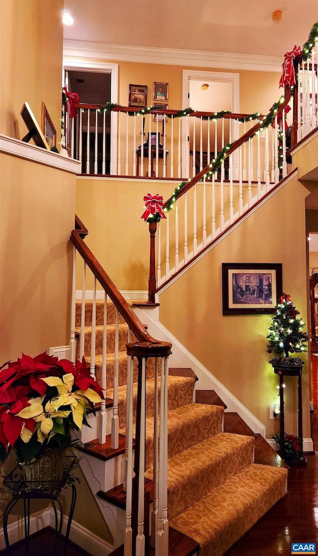 stairs featuring hardwood / wood-style floors and ornamental molding