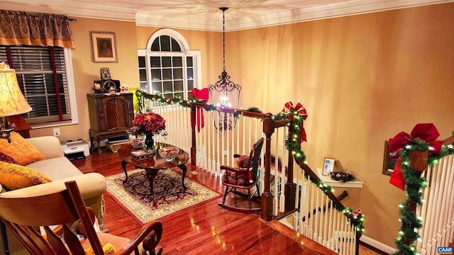 sitting room featuring hardwood / wood-style floors, ornamental molding, and a notable chandelier