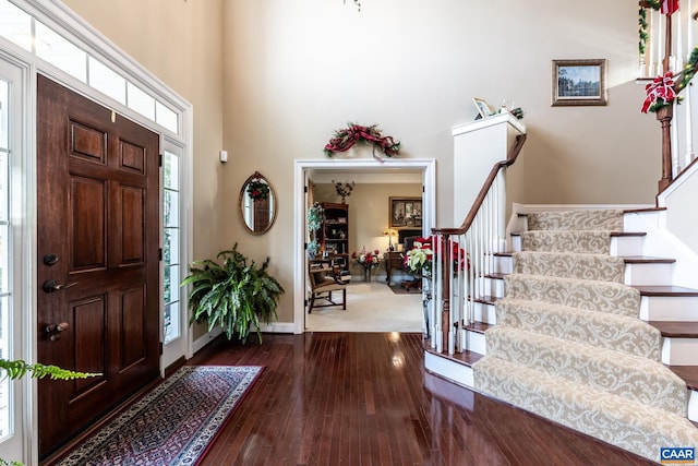 entryway featuring hardwood / wood-style flooring and a towering ceiling