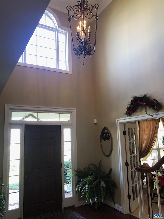 foyer entrance with a towering ceiling and a chandelier