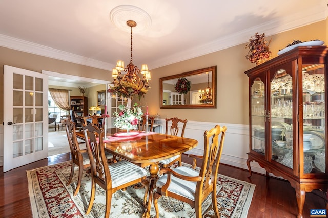 dining area featuring crown molding, dark hardwood / wood-style flooring, french doors, and an inviting chandelier