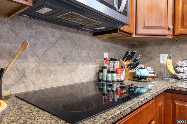 kitchen featuring black electric stovetop and tasteful backsplash