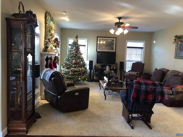 carpeted living area with ceiling fan