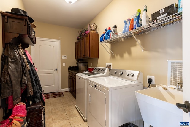 laundry room featuring cabinets, light tile patterned floors, separate washer and dryer, and sink