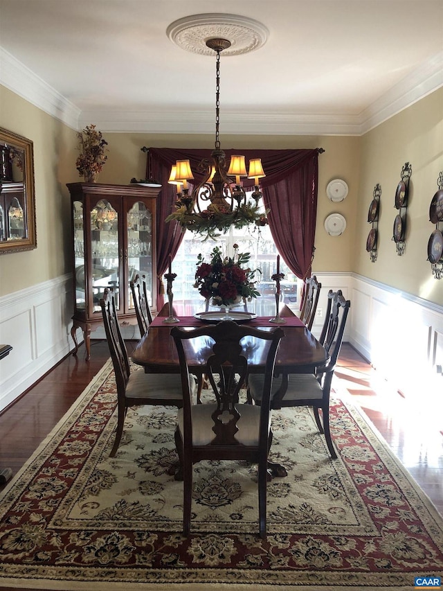 dining room with hardwood / wood-style flooring, crown molding, and a chandelier