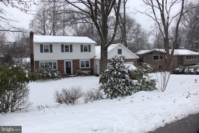 view of front of house with brick siding and a chimney