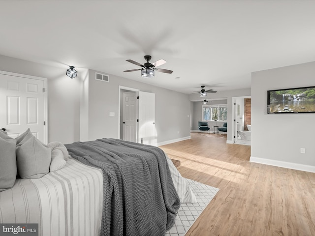 bedroom with ceiling fan, light hardwood / wood-style floors, and ensuite bathroom