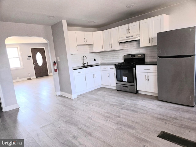 kitchen featuring backsplash, white cabinetry, and stainless steel appliances