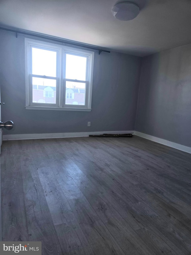 unfurnished room with dark wood-type flooring