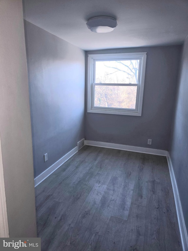 unfurnished room with dark wood-type flooring