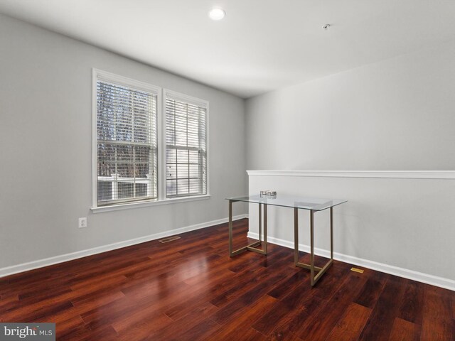 spare room featuring dark wood-type flooring