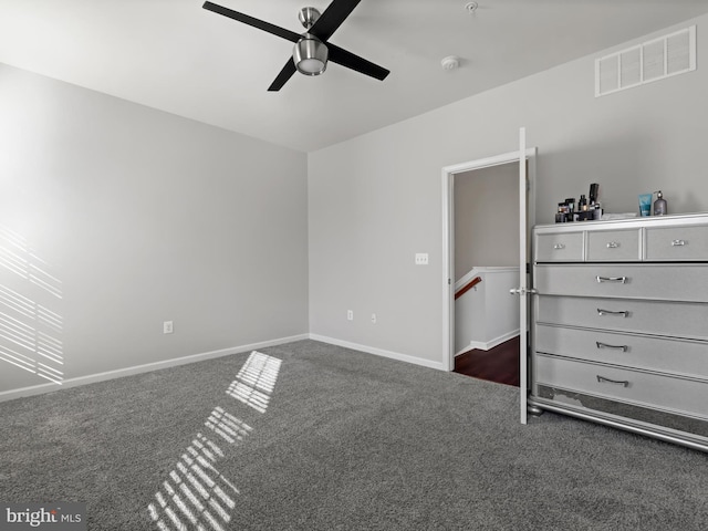 unfurnished bedroom with ceiling fan and dark carpet