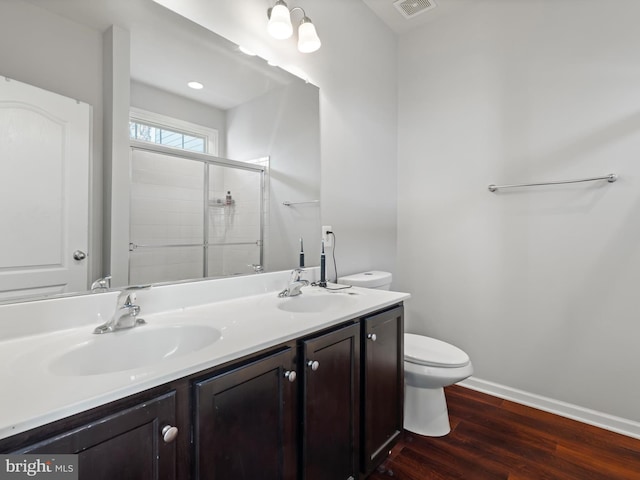 bathroom with toilet, hardwood / wood-style floors, vanity, and walk in shower