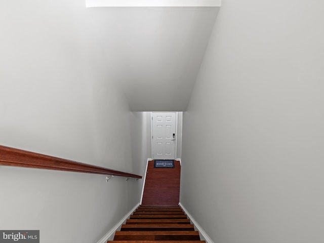 stairway featuring hardwood / wood-style floors and vaulted ceiling