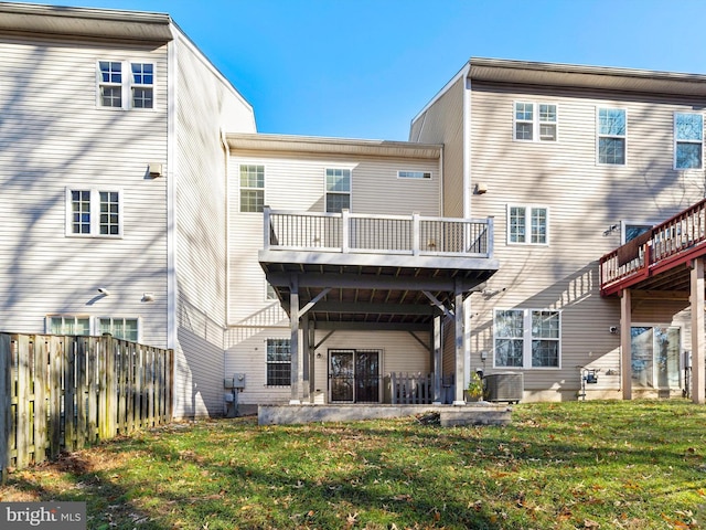 back of house featuring central air condition unit, a patio area, and a lawn