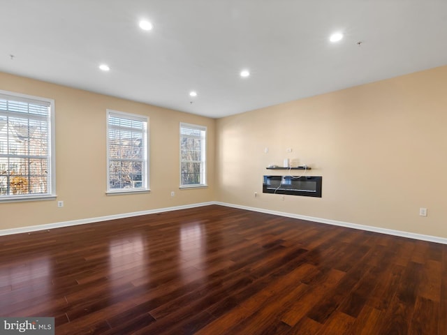 empty room with dark hardwood / wood-style flooring