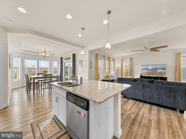 kitchen with pendant lighting, a kitchen island with sink, stainless steel dishwasher, light stone counters, and white cabinetry