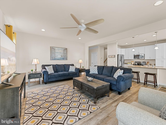 living room featuring light wood-type flooring and ceiling fan