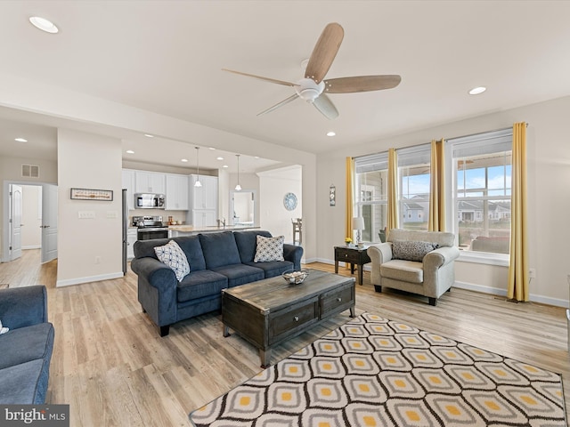 living room with light wood-type flooring and ceiling fan