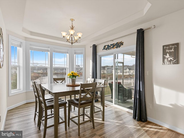 dining space featuring a chandelier, light wood-type flooring, and a wealth of natural light