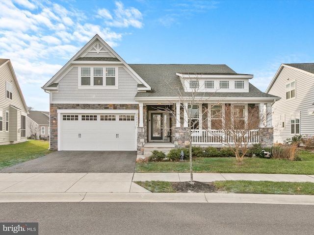 craftsman house featuring covered porch and a front yard