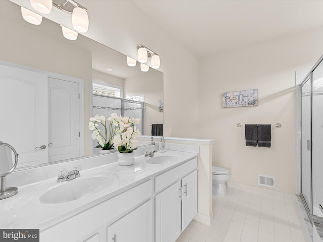 bathroom featuring tile patterned flooring, vanity, toilet, and an enclosed shower