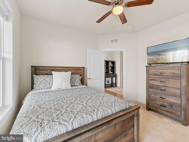 bedroom featuring light colored carpet and ceiling fan