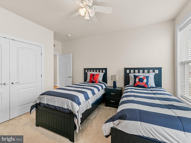 bedroom featuring a closet, light colored carpet, and ceiling fan